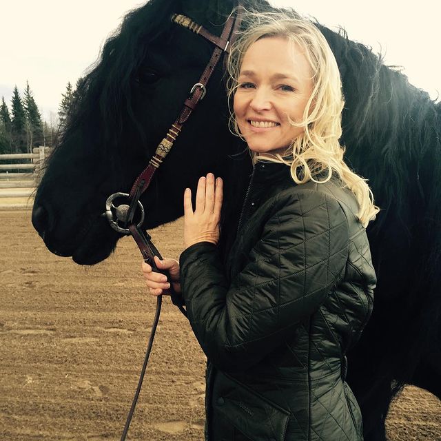 Kari Matchett wearing Black jacket holding Black Horse